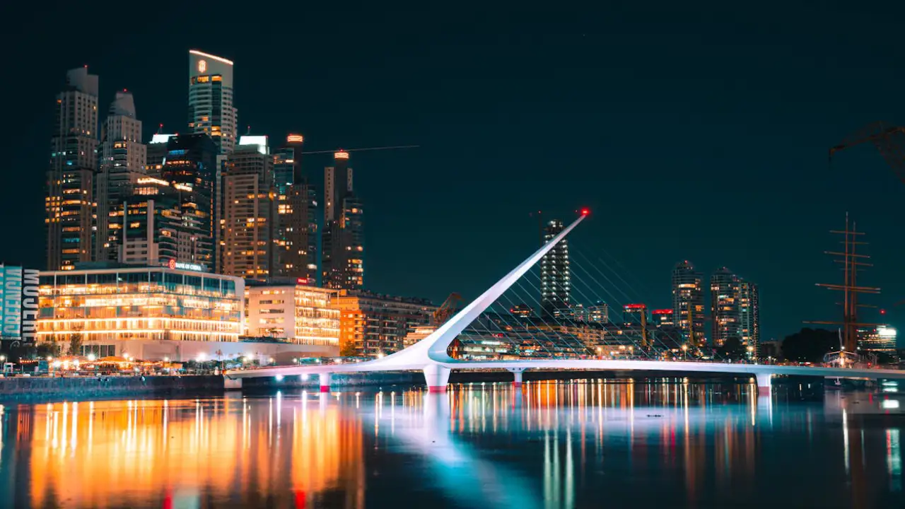 prédios à beira do lago a noite iluminado ao lado da ponte