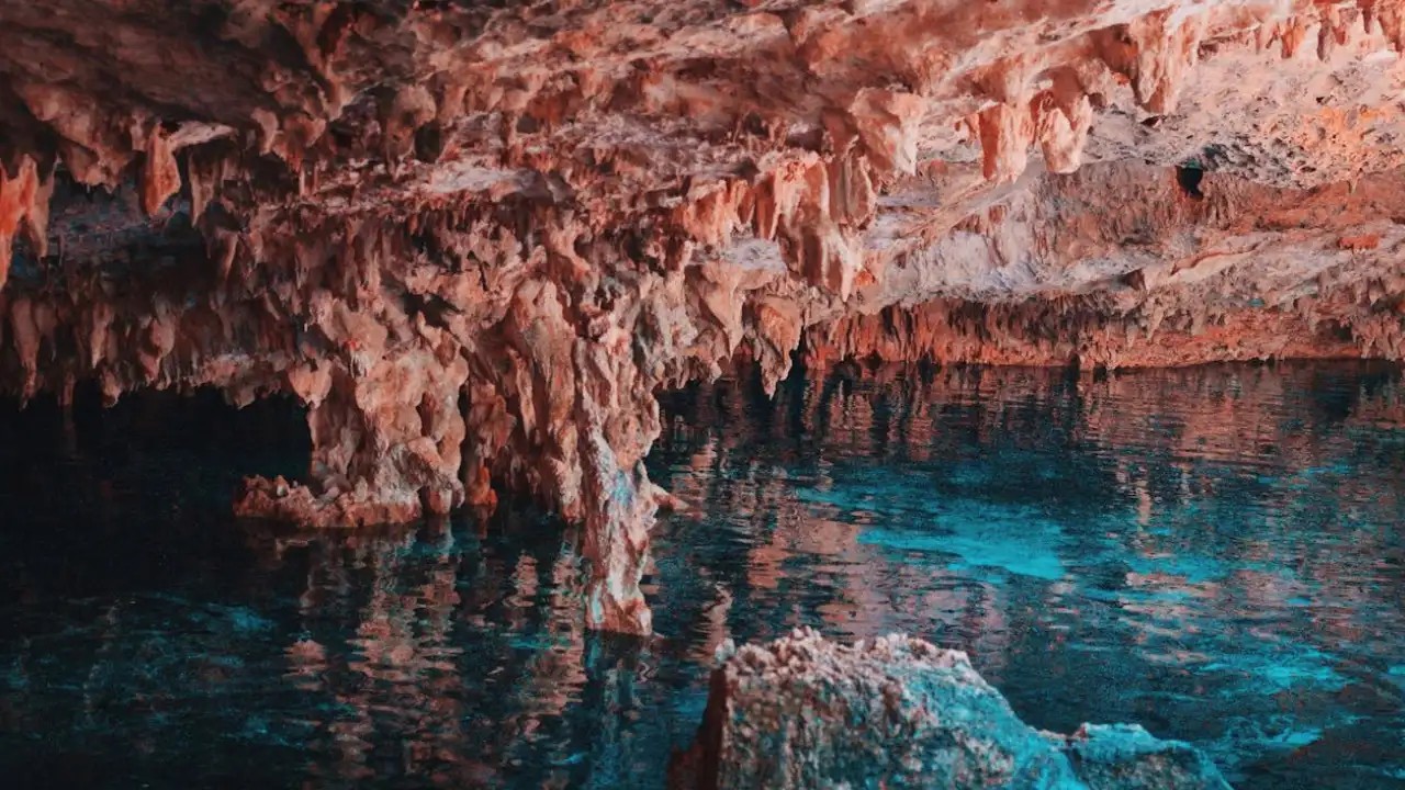 gruta com água azul cristalina e pedras em cancún