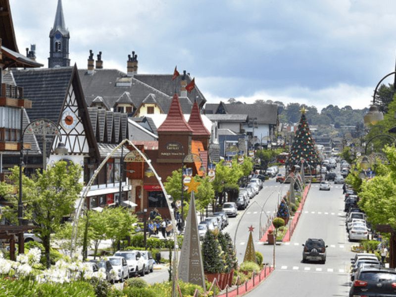 avenida na cidade de gramado com prédios coloniais e árvore de natal ao fundo