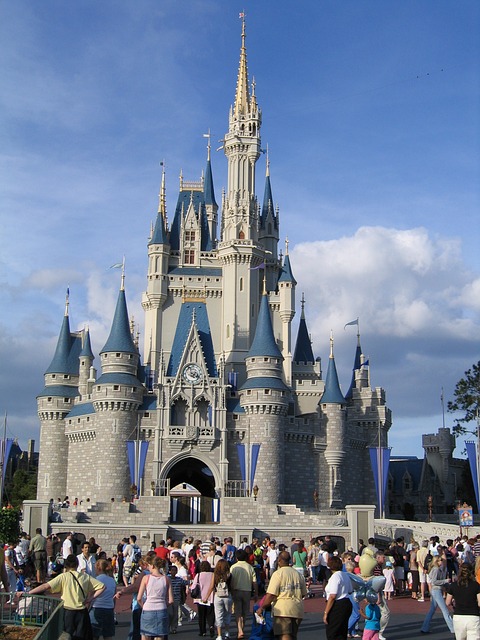 castelo do parque da disney Magic Kingdom com várias pessoas em frente passeando