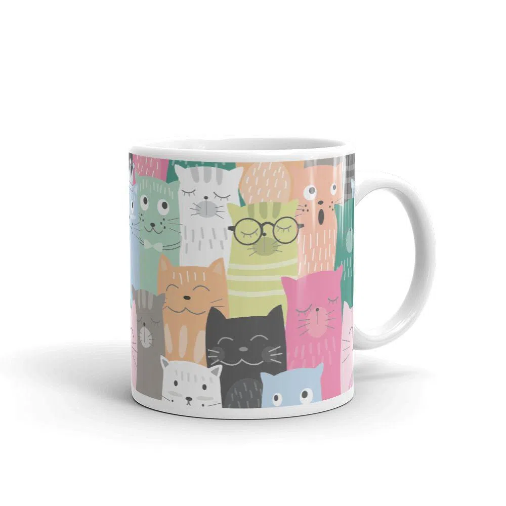  Caneca de café com fundo e alça branca e estampa com desenhos de gatinhos coloridos. 