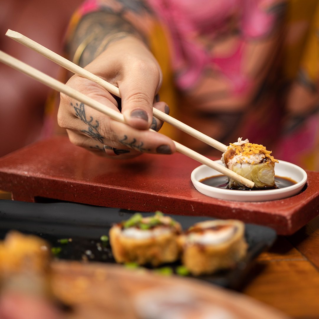 mão de uma pessoa servindo sushi no restaurante japonês